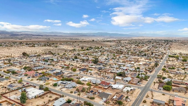 drone / aerial view with view of desert, a residential view, and a mountain view