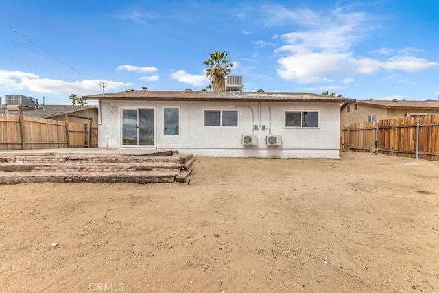 back of property featuring a fenced backyard, stucco siding, and central AC unit