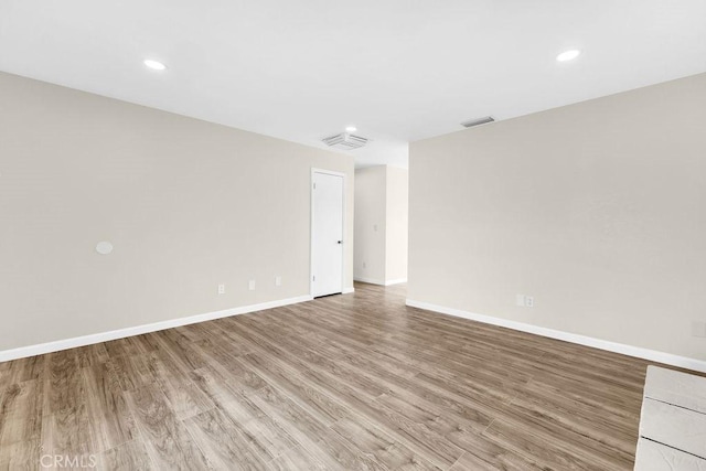 unfurnished room featuring visible vents, light wood-style flooring, baseboards, and recessed lighting