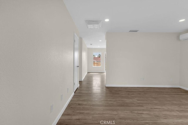 hallway featuring visible vents, wood finished floors, baseboards, and recessed lighting