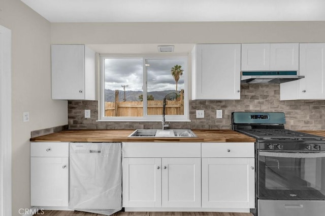 kitchen featuring a sink, stainless steel gas range oven, dishwashing machine, under cabinet range hood, and wooden counters