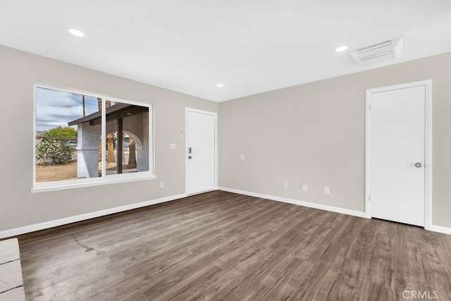 unfurnished living room with visible vents, wood finished floors, baseboards, and recessed lighting