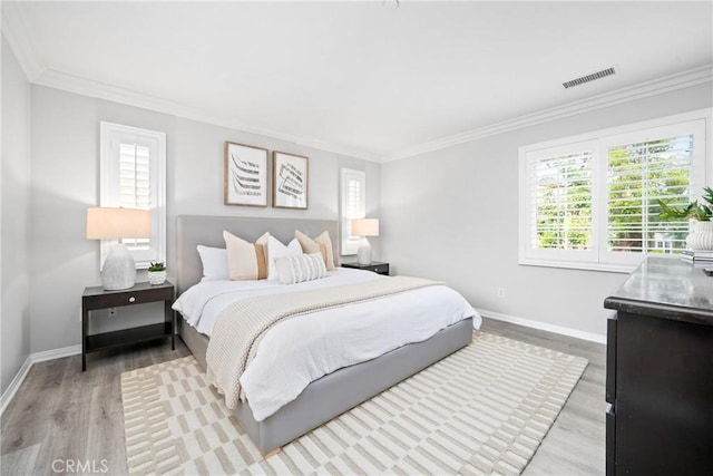 bedroom featuring ornamental molding, visible vents, and multiple windows