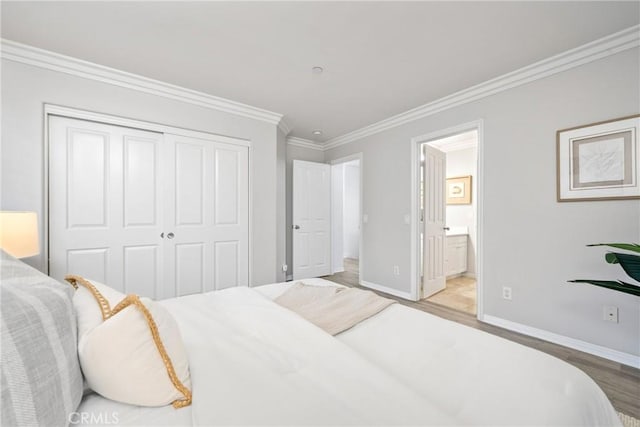 bedroom featuring crown molding, a closet, wood finished floors, and baseboards