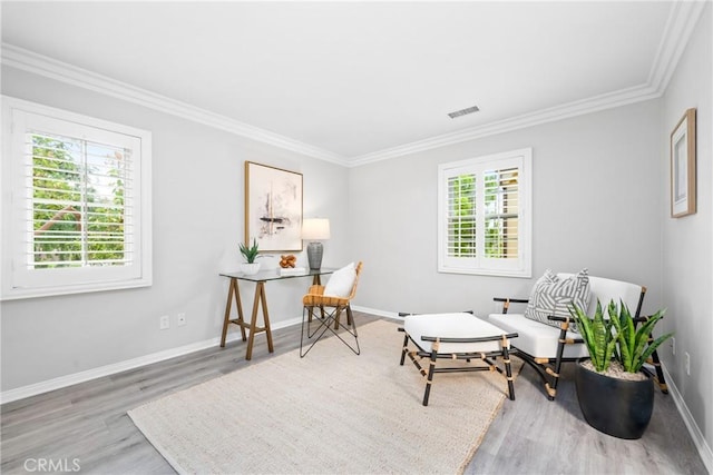 sitting room featuring crown molding, visible vents, plenty of natural light, and wood finished floors