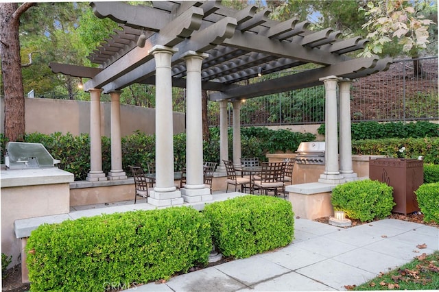 exterior space with a grill, a pergola, an outdoor kitchen, and fence
