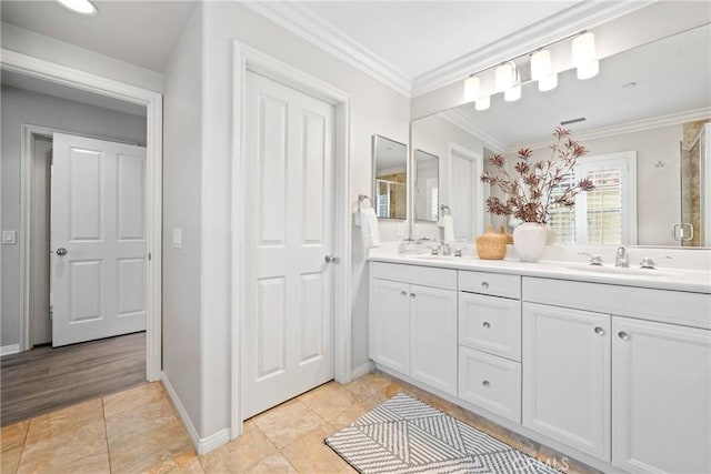 full bathroom with baseboards, ornamental molding, double vanity, and a sink