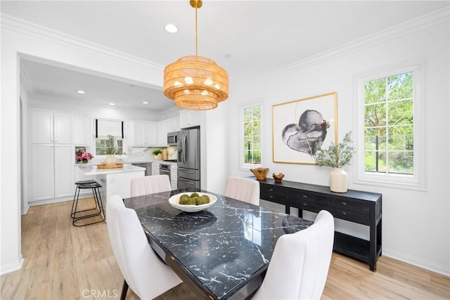 dining space with baseboards, light wood finished floors, ornamental molding, and a healthy amount of sunlight
