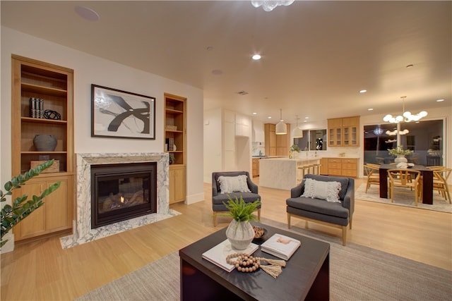 582 Paseo St, Arroyo Grande, CA 93420 - living area featuring light wood finished floors, a high end fireplace, a chandelier, built in features, and recessed lighting