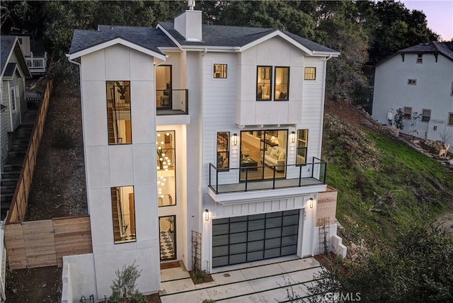 582 Paseo St, Arroyo Grande, CA 93420 - contemporary home with a balcony, fence, a chimney, a garage, and concrete driveway