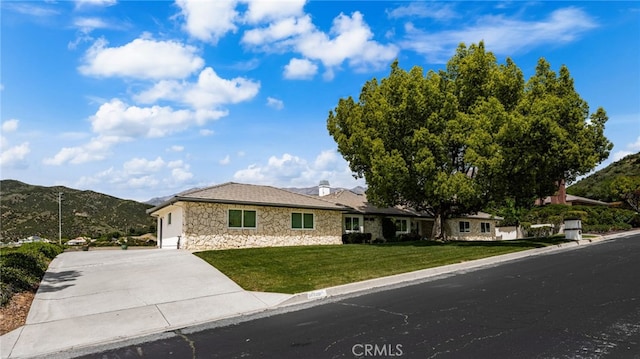 36608 Oak Ridge Dr, Yucaipa, CA 92399 - ranch-style house featuring stone siding, a front yard, an attached garage, concrete driveway, and a mountain view