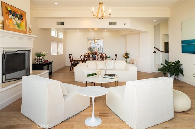 1624 Malden St, San Diego, CA 92109 - living room with a chandelier, crown molding, a fireplace with raised hearth, stairs, and light wood-style flooring