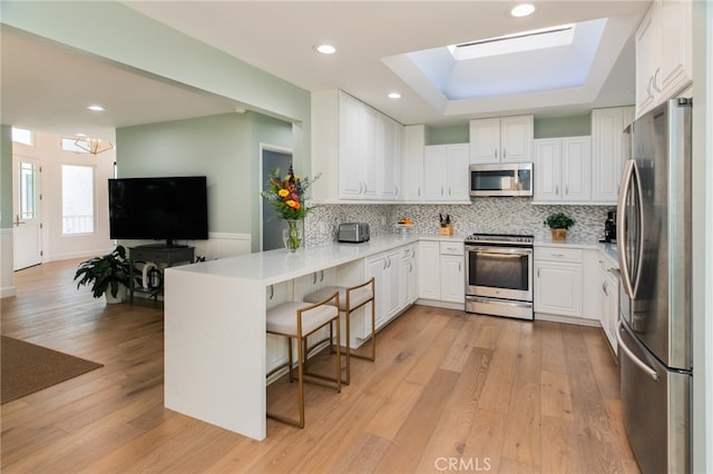 1624 Malden St, San Diego, CA 92109 - kitchen with appliances with stainless steel finishes, a peninsula, decorative backsplash, white cabinets, and recessed lighting