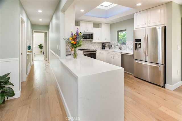 1624 Malden St, San Diego, CA 92109 - kitchen with appliances with stainless steel finishes, a peninsula, white cabinetry, tasteful backsplash, and recessed lighting