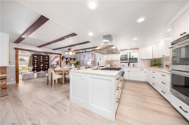 21128 Trigger Ln, Diamond Bar, CA 91765 - kitchen featuring island range hood, appliances with stainless steel finishes, a center island, decorative backsplash, and white cabinets