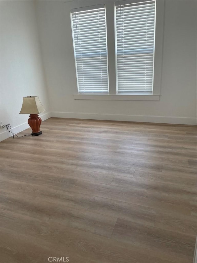 unfurnished room with wood finished floors and baseboards
