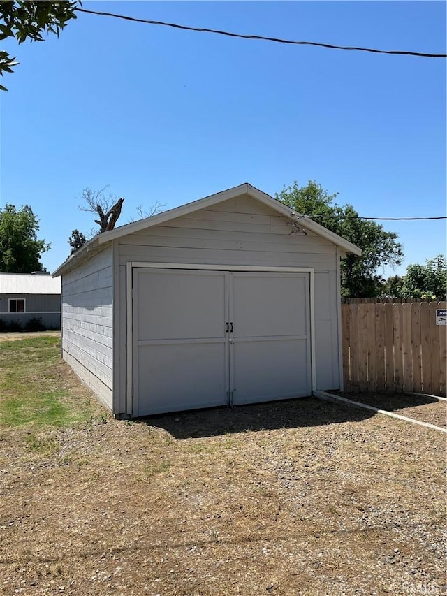 detached garage with driveway and fence