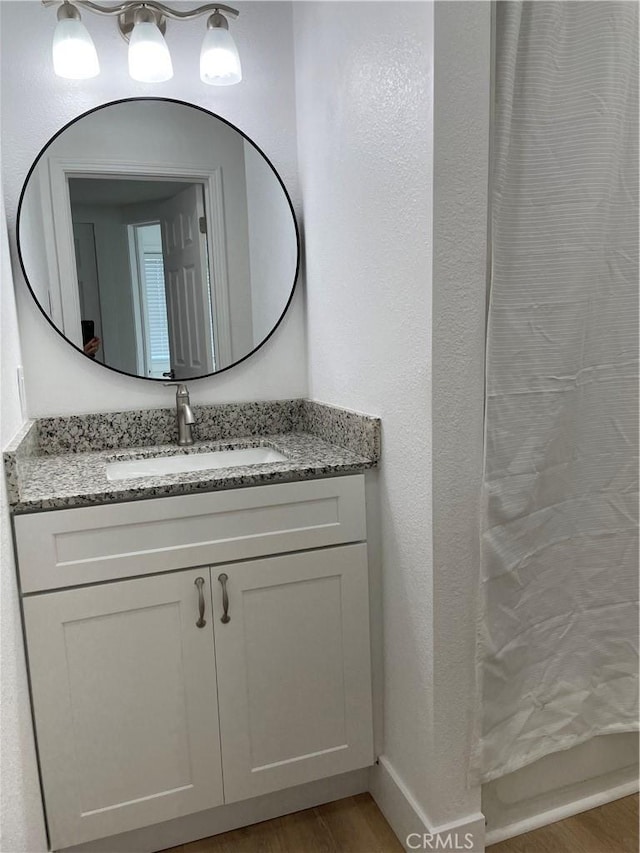 bathroom with wood finished floors and vanity