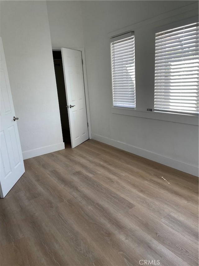 unfurnished bedroom featuring wood finished floors and baseboards