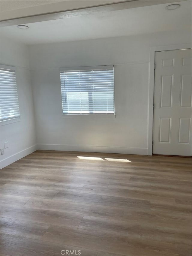 unfurnished room featuring baseboards and wood finished floors