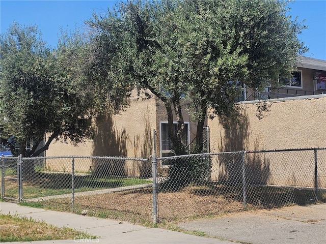 view of side of home featuring stucco siding and fence private yard