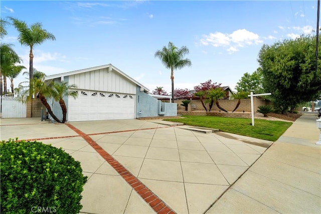 single story home with driveway, board and batten siding, a garage, and fence