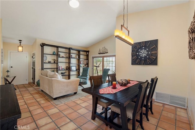 dining area featuring vaulted ceiling, light tile patterned floors, and visible vents
