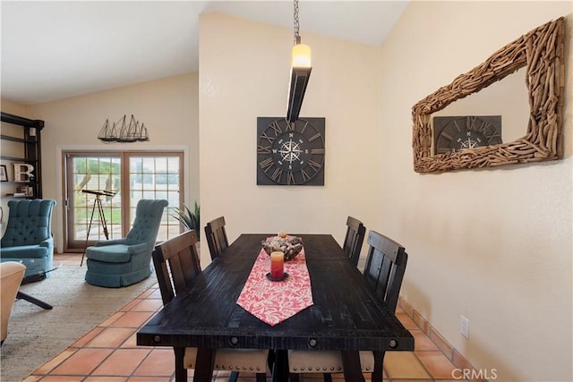 dining room featuring lofted ceiling and tile patterned floors