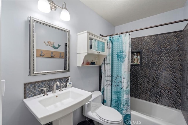 full bathroom featuring shower / bathtub combination with curtain, toilet, and a sink