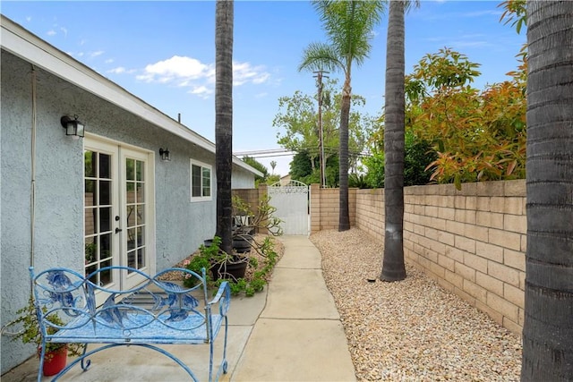fenced backyard with french doors and a gate