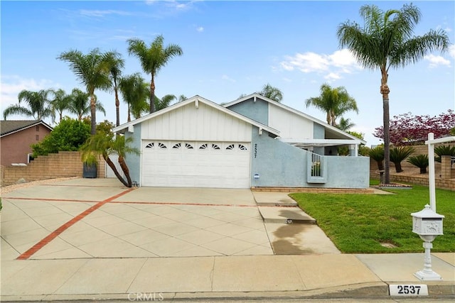 view of front of house featuring driveway, fence, a garage, stucco siding, and a front lawn
