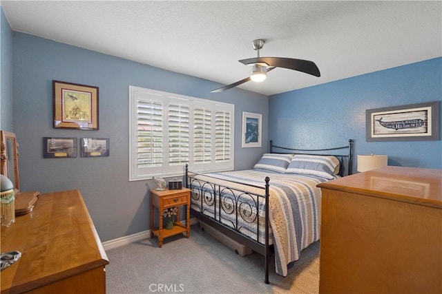 bedroom featuring carpet floors, a textured wall, a textured ceiling, and a ceiling fan