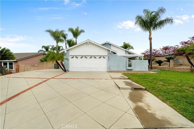 view of front of house featuring an attached garage, driveway, and a front yard