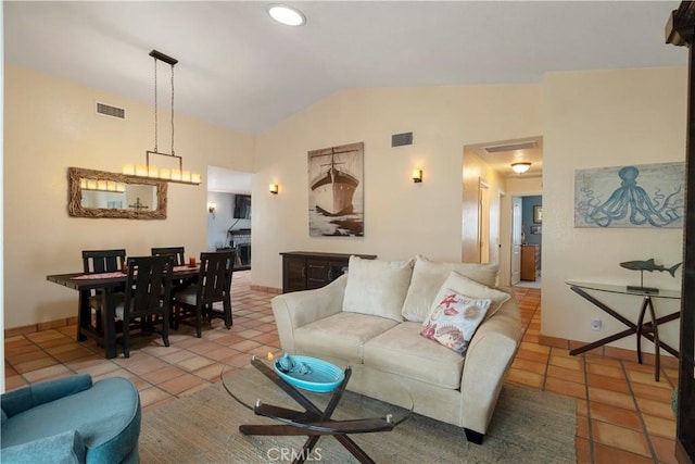 tiled living area featuring visible vents, baseboards, and lofted ceiling