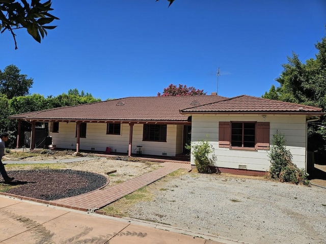 view of front of house with a tiled roof and crawl space