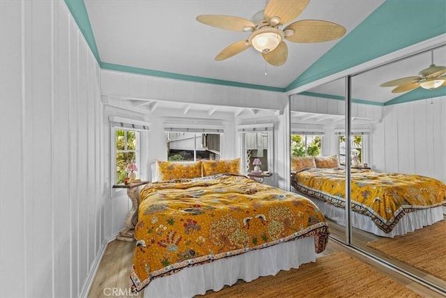bedroom with wood finished floors, lofted ceiling, and ceiling fan