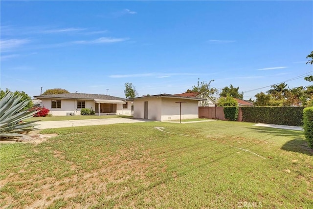 back of property with driveway and stucco siding