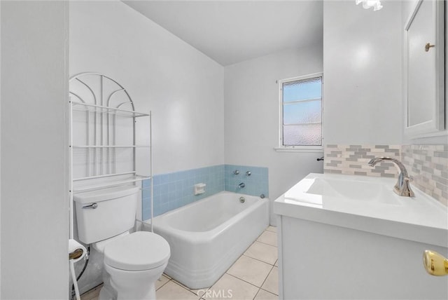 bathroom featuring tile patterned flooring, a bath, toilet, vanity, and tasteful backsplash