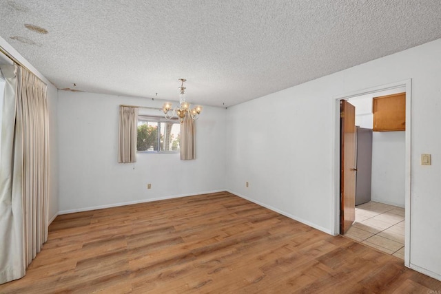 6552 Mallard St, San Diego, CA 92114 - unfurnished room with wood finished floors, a chandelier, a textured ceiling, and baseboards