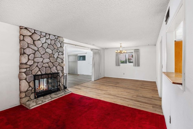 6552 Mallard St, San Diego, CA 92114 - unfurnished living room with a textured ceiling, a fireplace, wood finished floors, and a chandelier