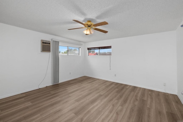 6552 Mallard St, San Diego, CA 92114 - unfurnished room featuring ceiling fan, a wall unit AC, wood finished floors, a textured ceiling, and baseboards