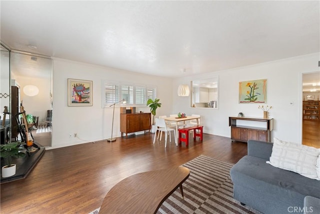 living area featuring crown molding and wood finished floors