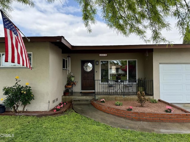 entrance to property with an attached garage, stucco siding, and covered porch