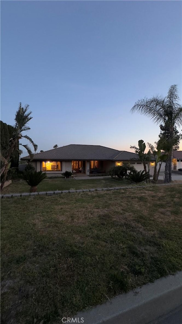single story home featuring a lawn