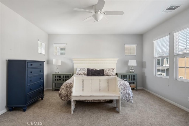 bedroom featuring light carpet, visible vents, and multiple windows