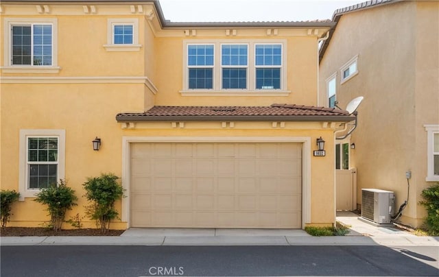 multi unit property with concrete driveway, a garage, stucco siding, a tiled roof, and cooling unit