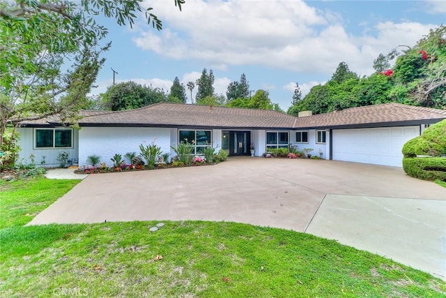 ranch-style house with a garage, driveway, and a front yard