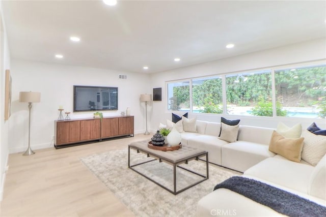 living room featuring recessed lighting, light wood-type flooring, and baseboards