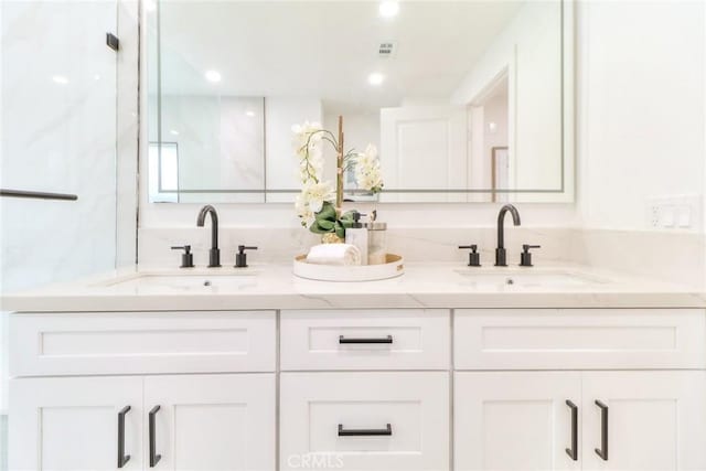 bathroom featuring double vanity and recessed lighting