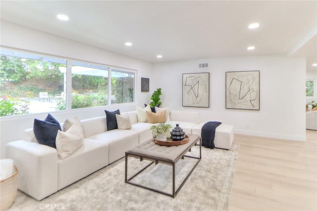 living room with recessed lighting, light wood finished floors, and baseboards